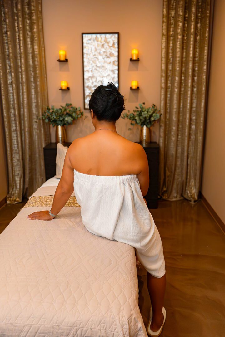 Woman in towel on spa table with candles
